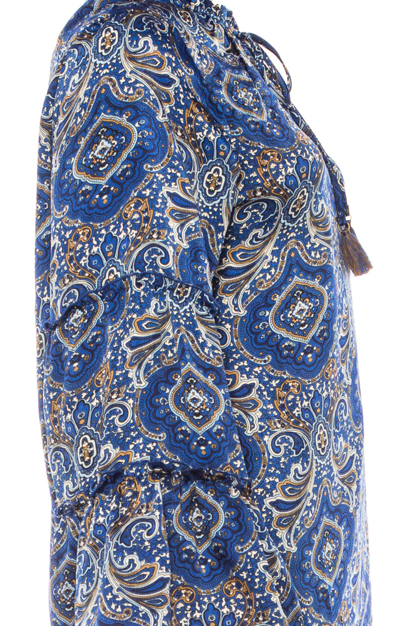 Close-up of a blue and gold paisley print women's blouse with tassel detail.