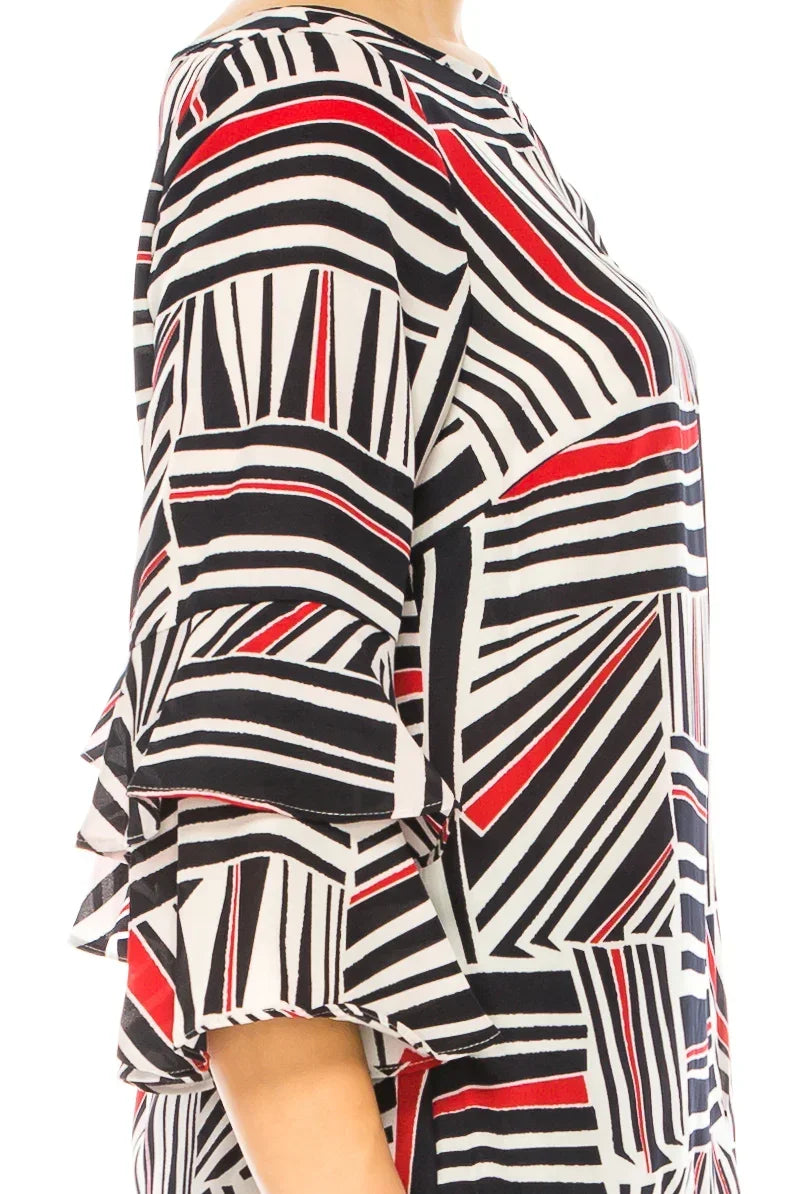 Woman wearing a white blouse with a red and black geometric striped pattern and ruffle sleeves.