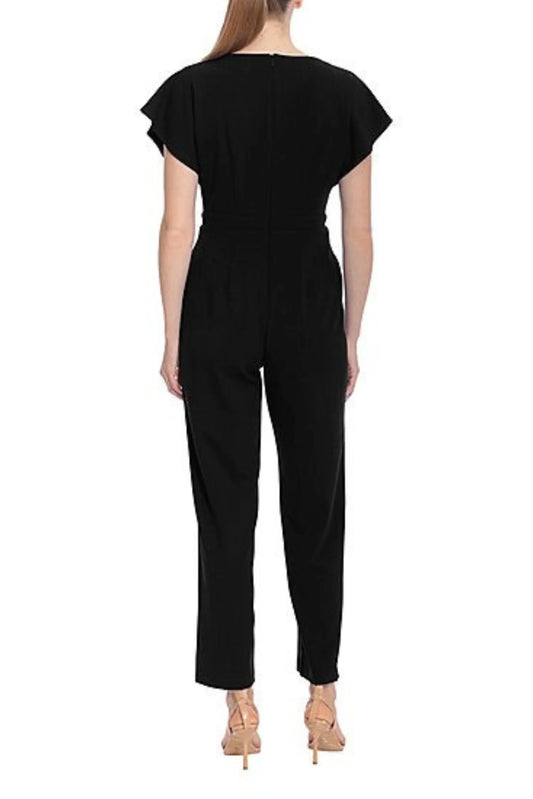 Rear view of a woman wearing a black short-sleeved evening jumpsuit and nude heels.