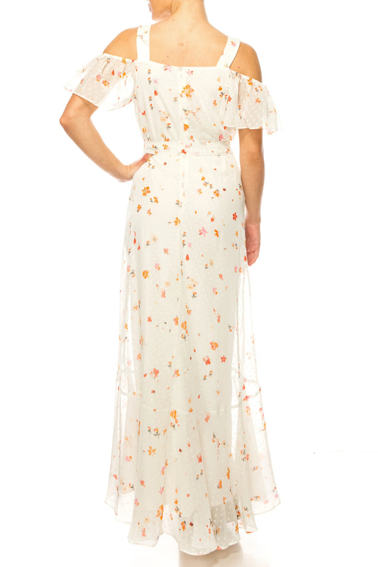 Back view of a woman wearing a white floral maxi dress with off-the-shoulder sleeves.