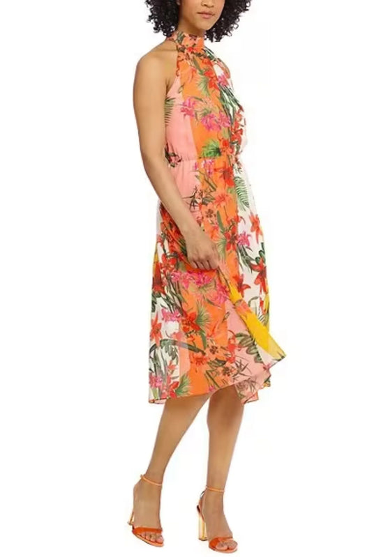Woman wearing a floral print halter neckline midi dress in orange and pink tones.