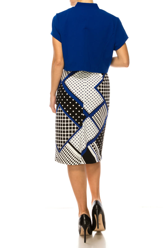 Back view of a woman wearing a blue short-sleeved top and a geometric patterned midi skirt