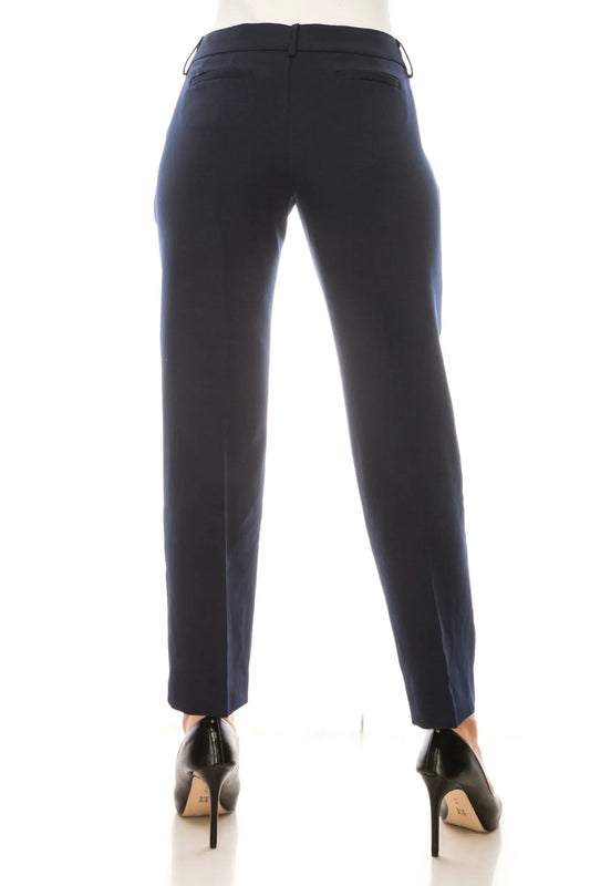 Rear view of a woman wearing navy blue tailored dress pants and black stiletto heels.