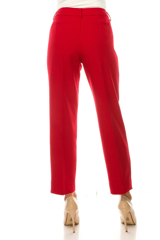 Rear view of a woman wearing tailored red dress pants and beige pointed-toe heels.