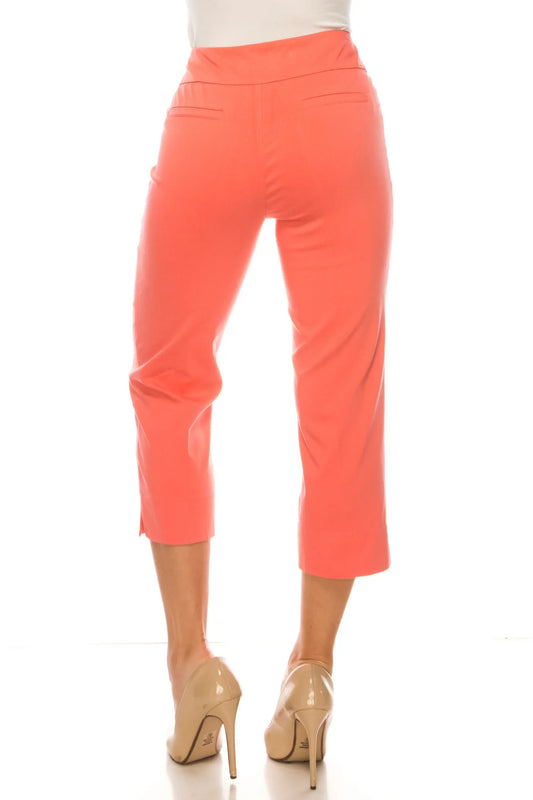 Back view of a woman wearing coral-pink cropped dress pants and nude high heels.