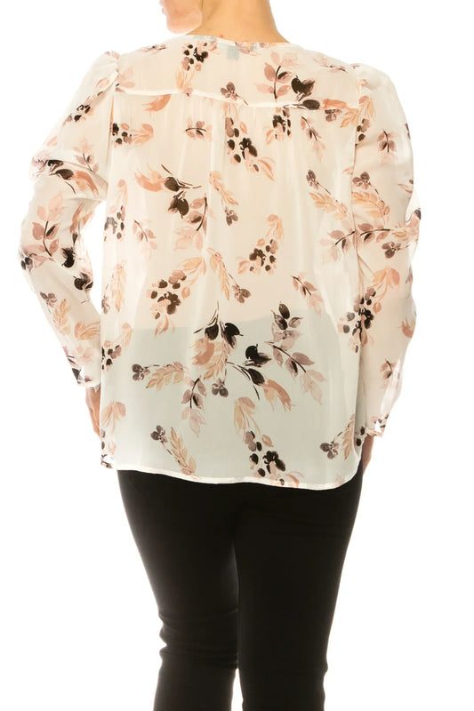 Back view of a woman wearing a white floral print long sleeve blouse and black pants