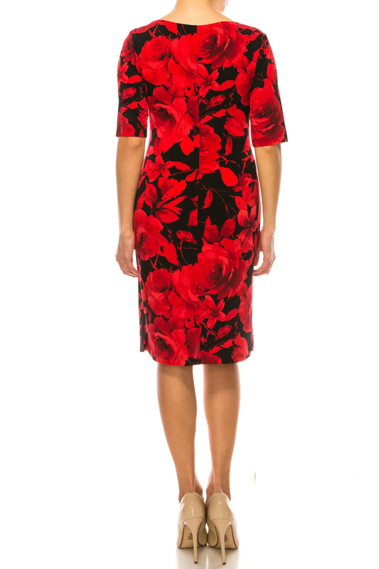 Rear view of a woman wearing a knee-length black and red floral print dress and beige heels.