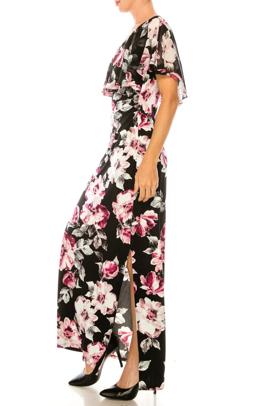 Woman wearing a black floral maxi dress with a side slit and black pointed-toe heels