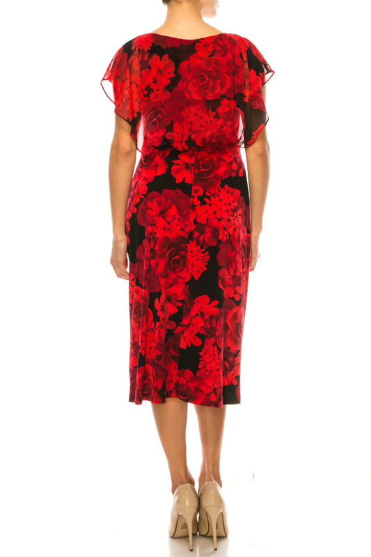 Back view of a woman wearing a red and black floral print midi dress and beige pumps.