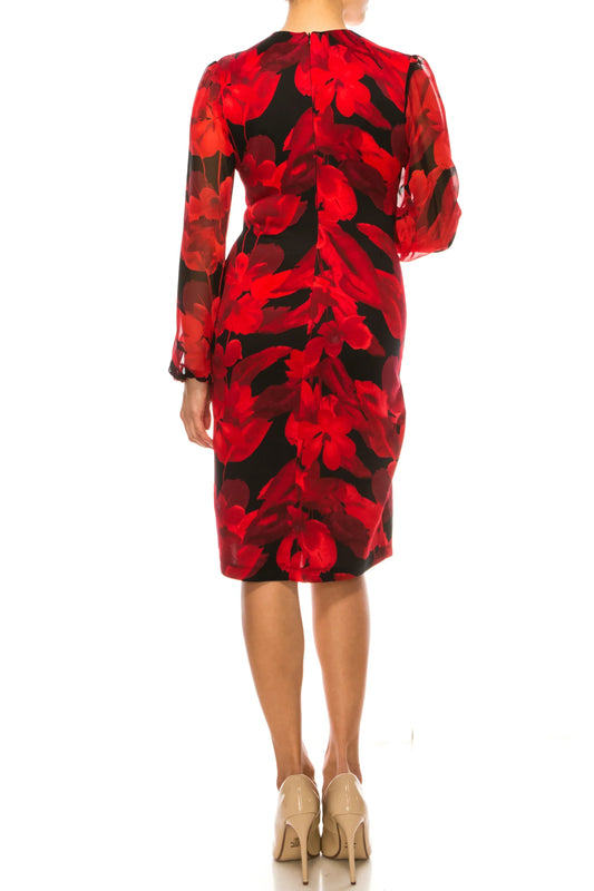 Back view of a woman wearing a red and black floral print long sleeve midi dress and beige heels.
