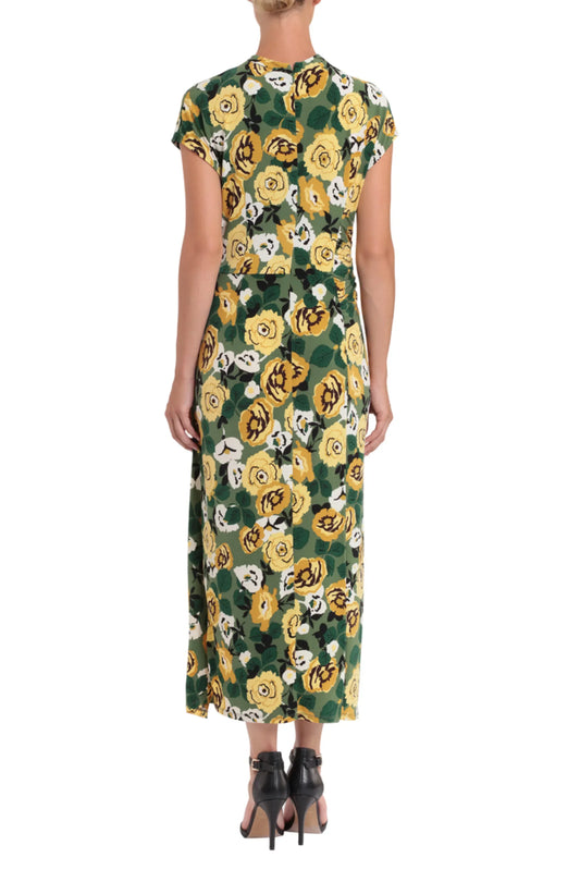 Back view of a woman wearing a green floral print maxi dress and black heels.