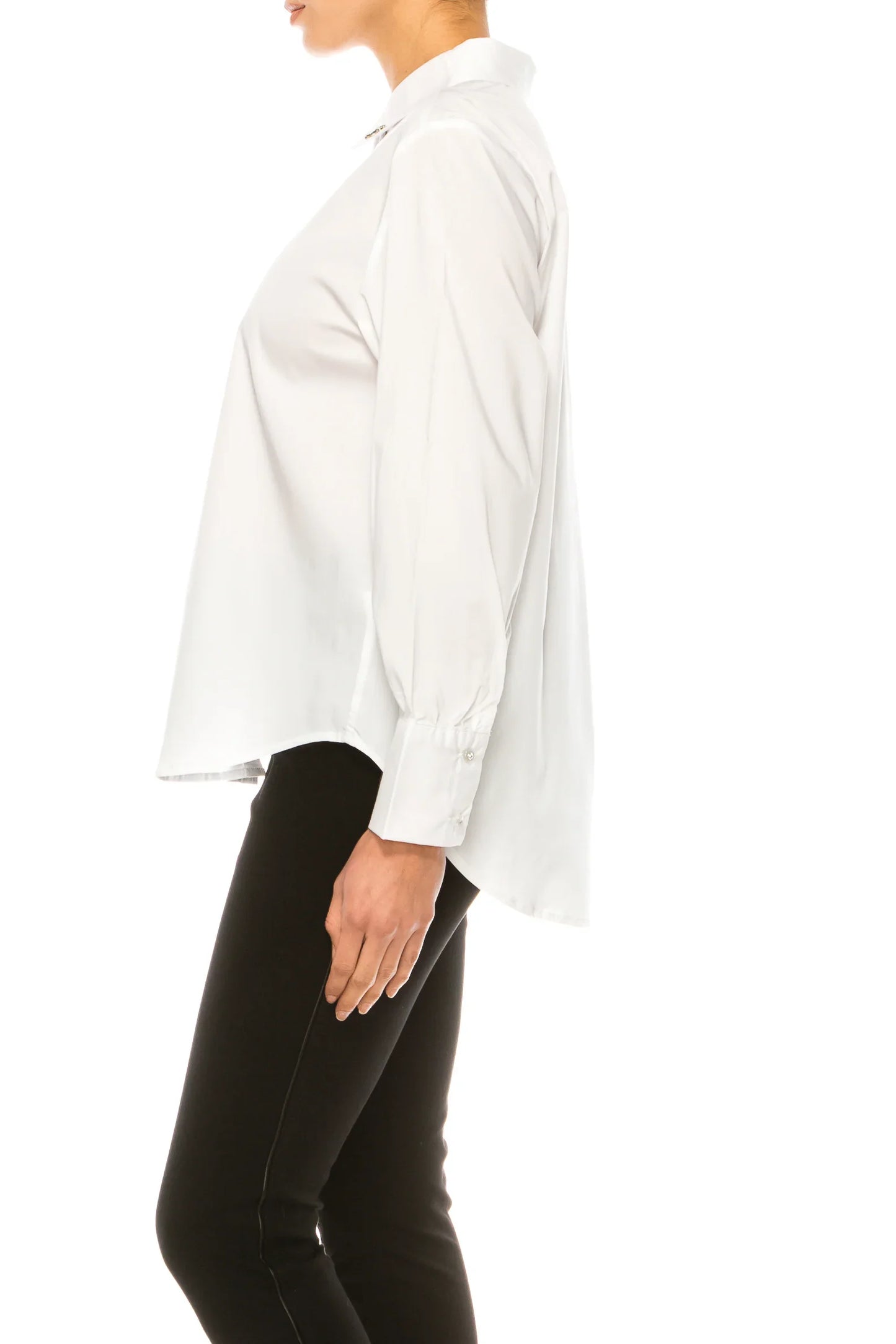 Side view of a woman wearing a classic white long-sleeve button-down shirt and black trousers.