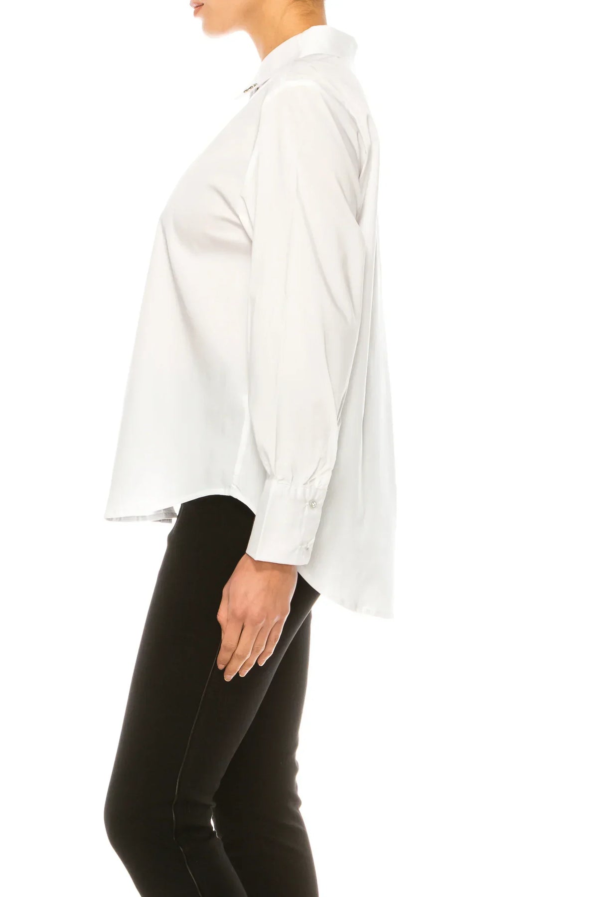 Side view of a woman wearing a classic white long-sleeve button-down shirt and black trousers.