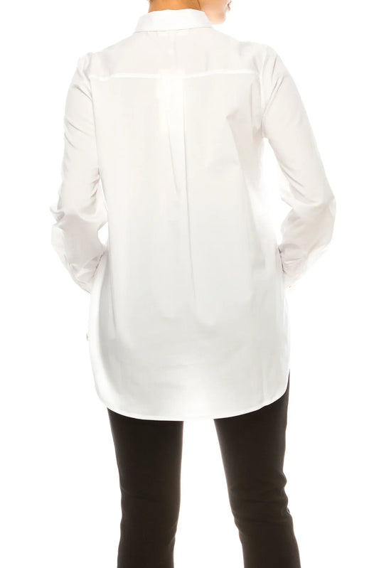Back view of a woman wearing a long-sleeved white button-down tunic and black trousers