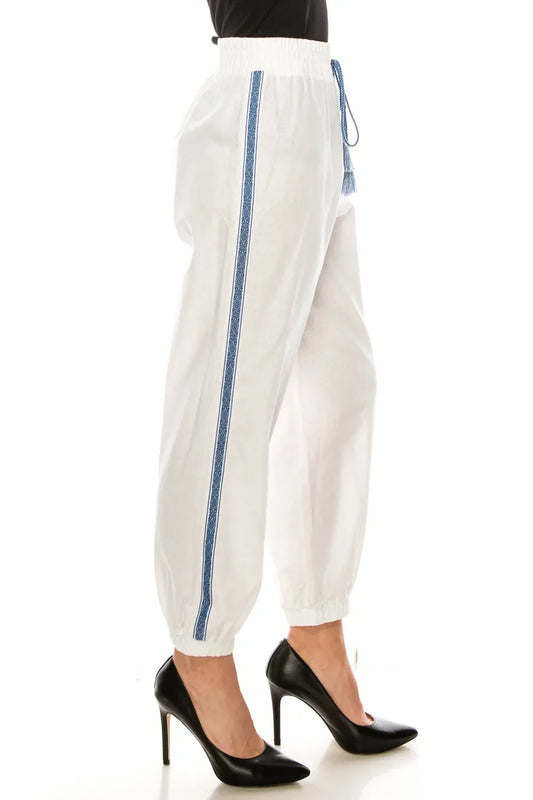Women's white elastic waist trousers with blue side stripe and black high heels