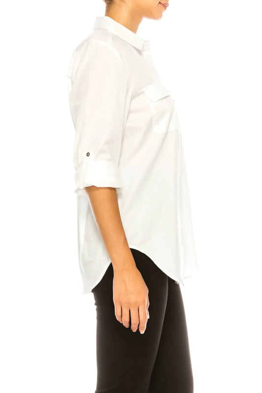 Side view of a woman wearing a white button-down long sleeve shirt and black pants.