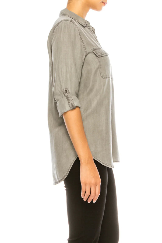 Side view of a woman wearing a grey button-down shirt with rolled sleeves and black pants.
