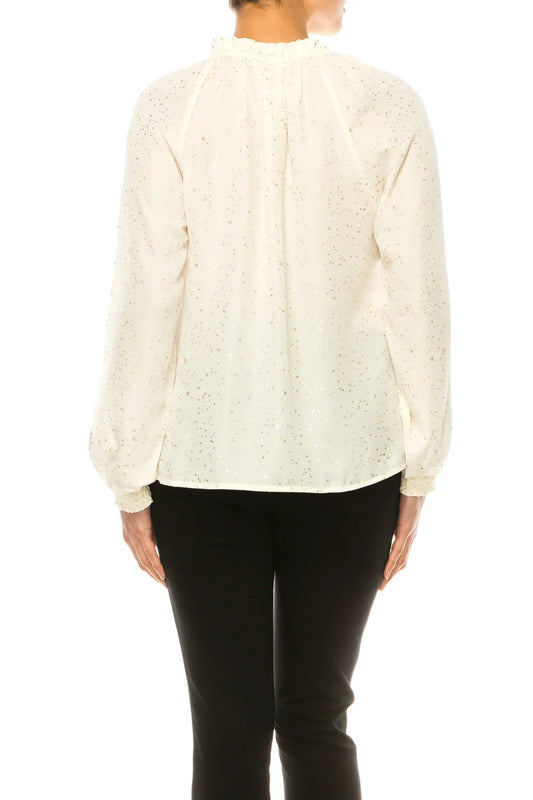 Back view of a woman wearing a white blouse with gold foil dots and black trousers