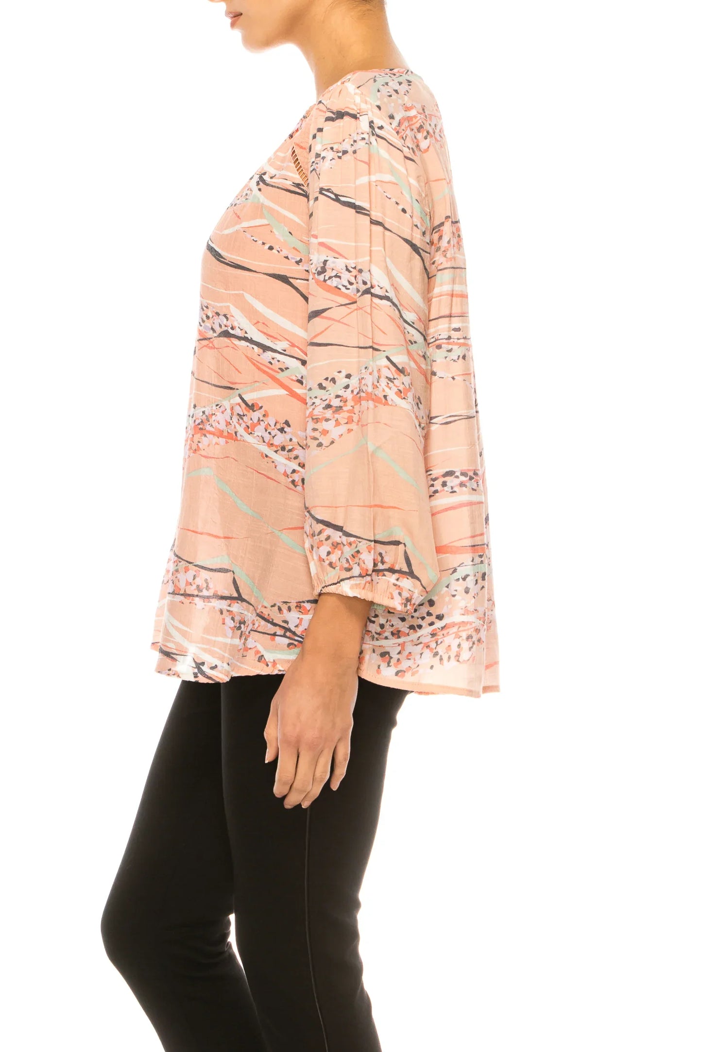 Woman wearing a pink abstract print long sleeve blouse and black trousers