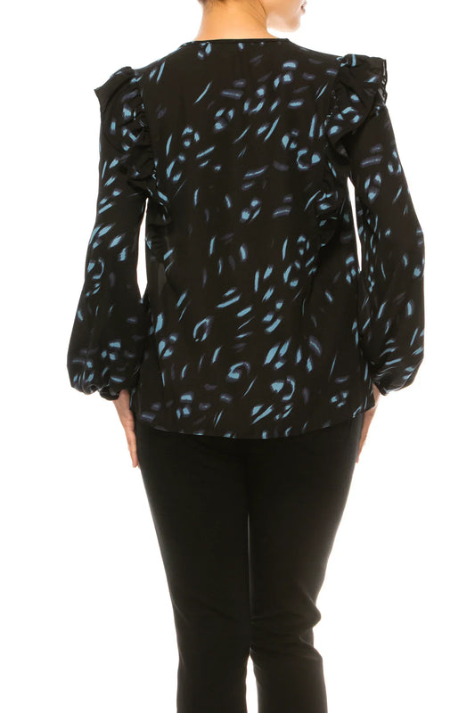 Back view of a woman wearing a black long-sleeve blouse with blue abstract print and ruffles.