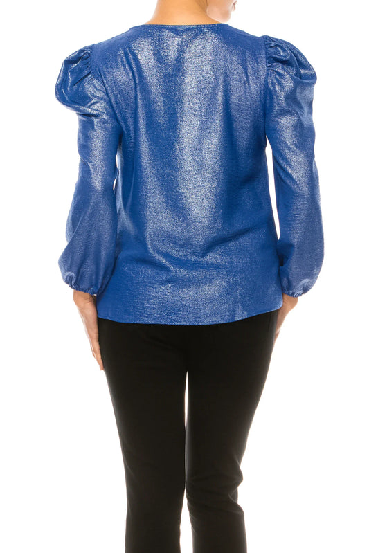 Rear view of a woman wearing a shimmering blue metallic puff sleeve blouse and black pants.