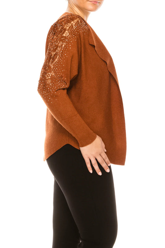 Woman wearing a rust-colored long-sleeve top with lace and rhinestone sleeve details.
