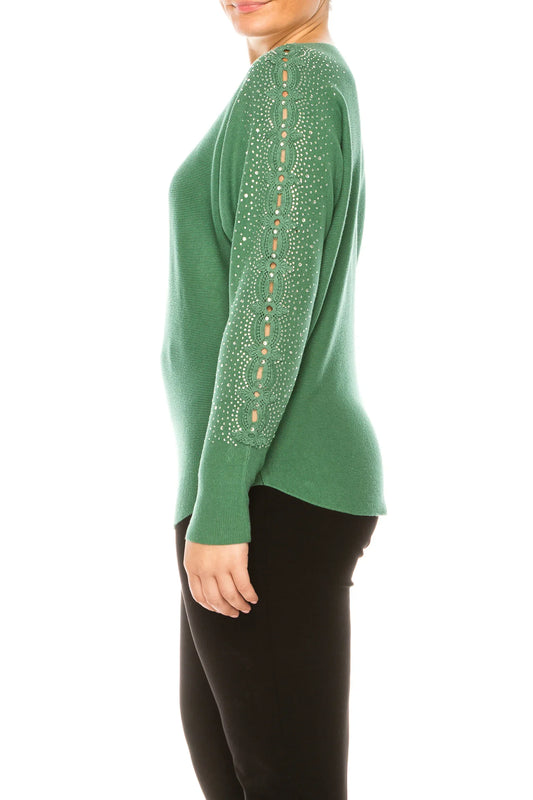 Woman wearing a green long sleeve sweater with rhinestone detailing on the sleeves.