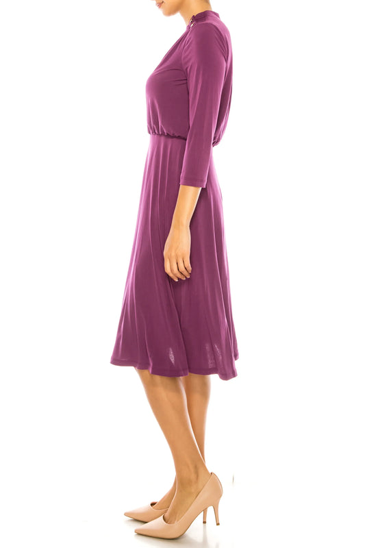 Woman in a purple three-quarter sleeve midi dress and beige pumps