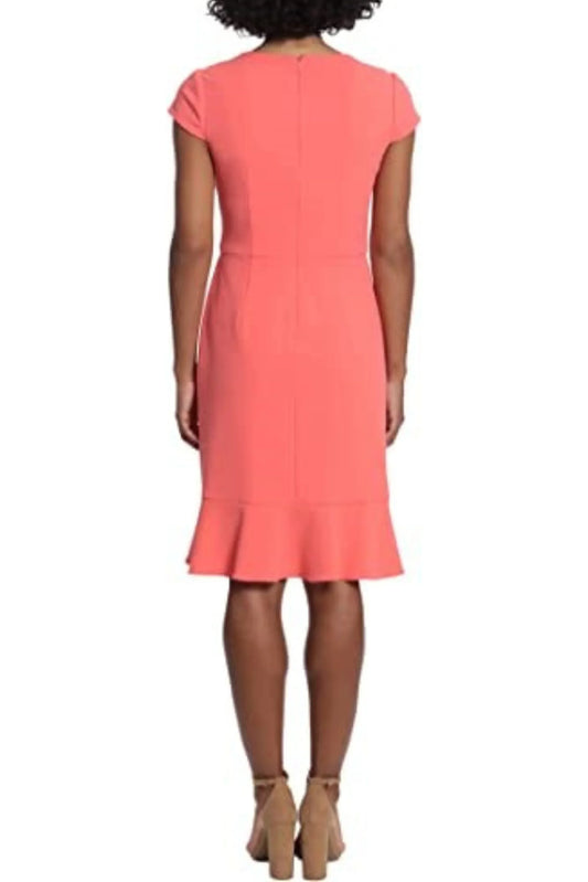 Back view of a woman wearing a coral short-sleeve sheath dress with a flounce hem.