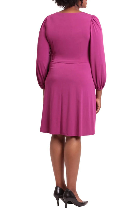 Back view of a woman wearing an elegant magenta long-sleeve knee-length dress and black heels.