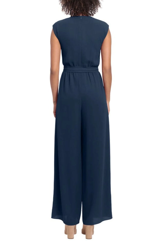 Rear view of a woman wearing a navy blue sleeveless wide-leg jumpsuit with a waist tie.
