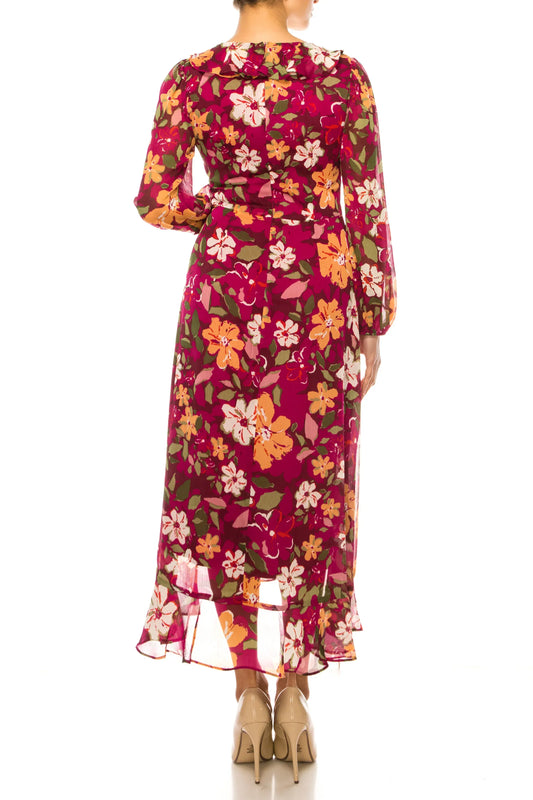 Back view of a woman wearing a magenta long-sleeve floral maxi dress and nude heels.