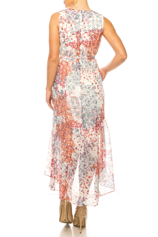 Back view of a woman wearing a sleeveless floral print maxi dress and nude heels.