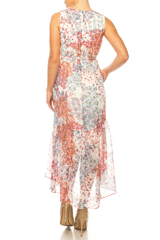 Back view of a woman wearing a sleeveless floral print maxi dress and nude heels.