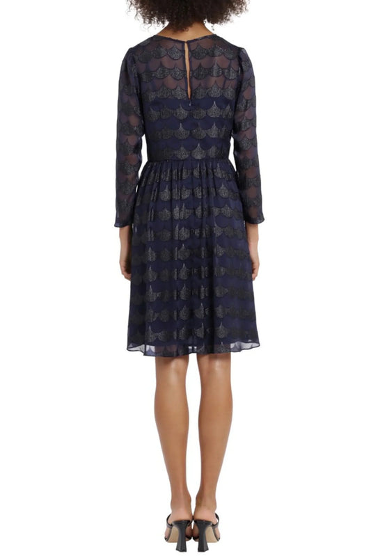 Back view of a woman wearing a navy blue patterned long-sleeve cocktail dress