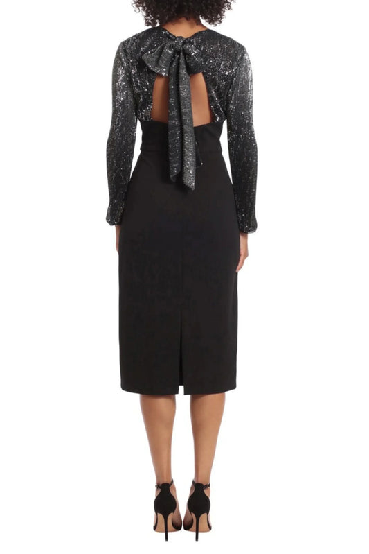Back view of a woman wearing a black midi dress with silver sequin sleeves and a bow tie