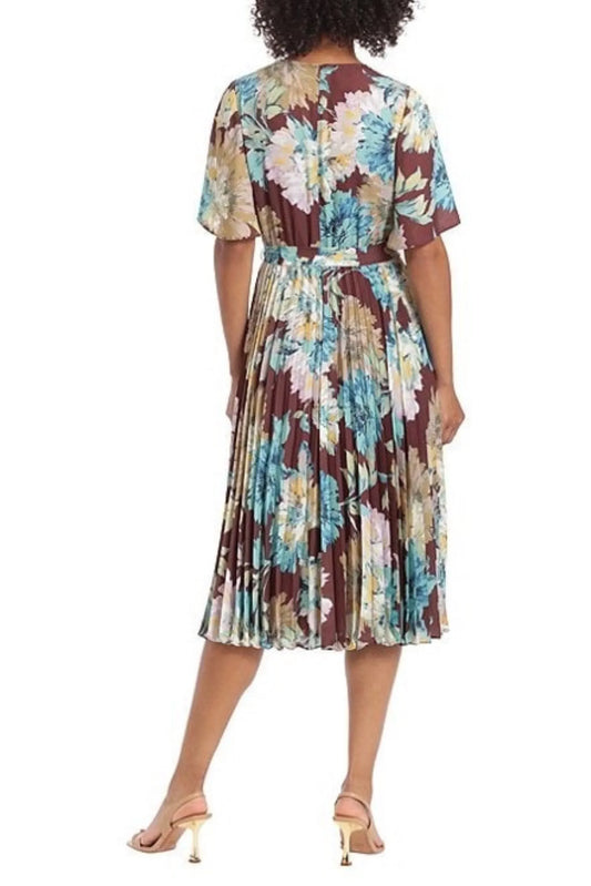 Back view of a woman wearing a floral print pleated midi dress with gold sandals