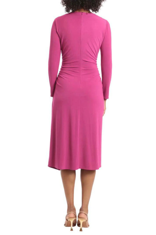Back view of a woman wearing a long-sleeved fuchsia midi dress and gold heels.