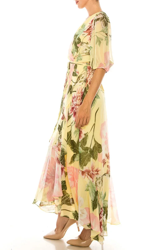 Woman wearing a yellow floral maxi dress with short sleeves and beige heels