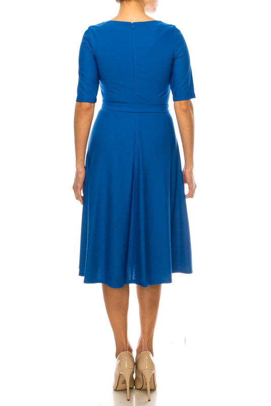 Back view of a woman wearing a royal blue midi dress and nude heels.