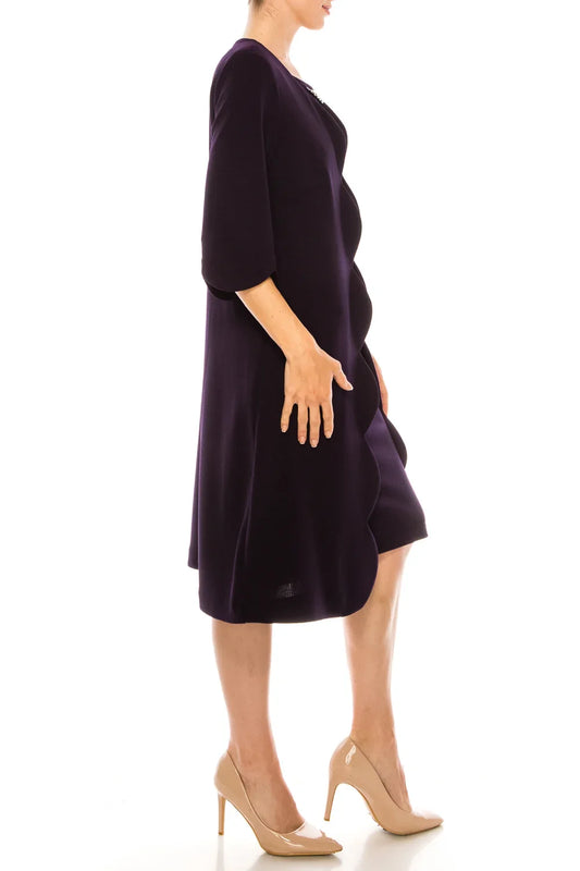 Woman in a purple mid-length dress with scalloped edges and nude heels