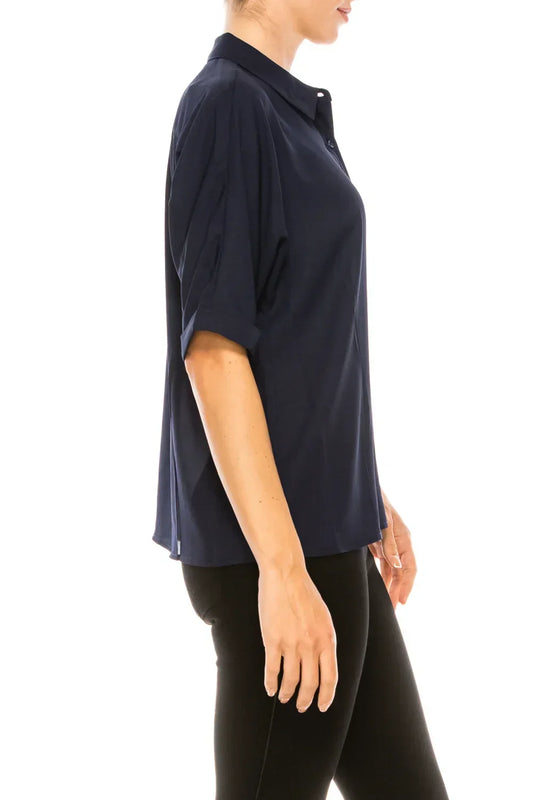 Side view of a woman wearing a navy blue short-sleeved button-down blouse and black pants.