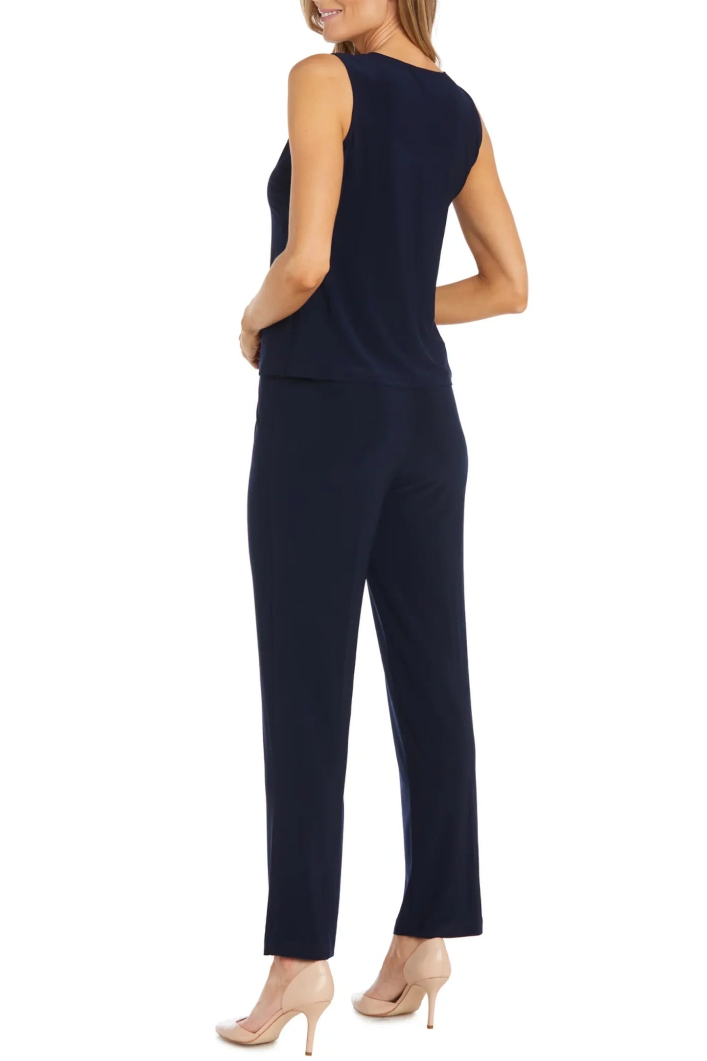 Back view of a woman wearing a navy blue sleeveless top and matching dress pants.