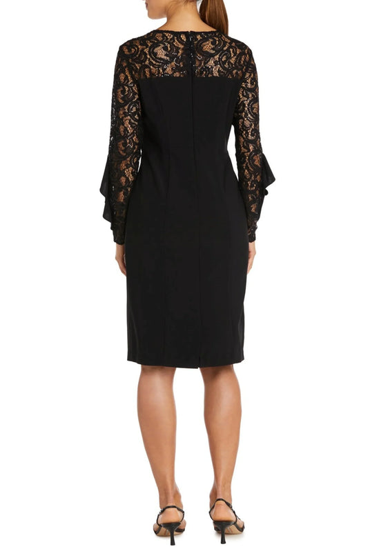 Back view of a woman wearing an elegant black sheath dress with lace sleeves and yoke