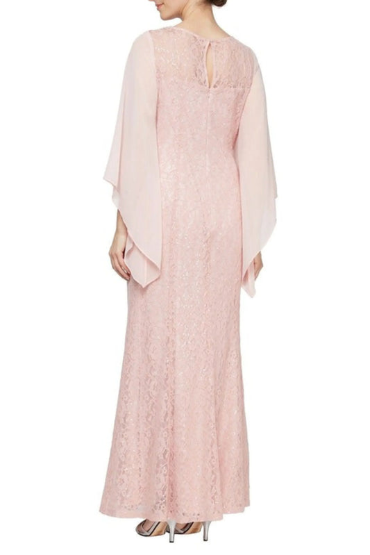 Back view of a woman wearing a light pink lace maxi dress with flowing cape sleeves