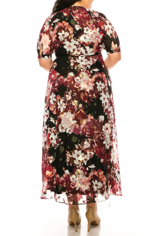 Back view of a woman wearing a black floral print midi dress and nude heels.