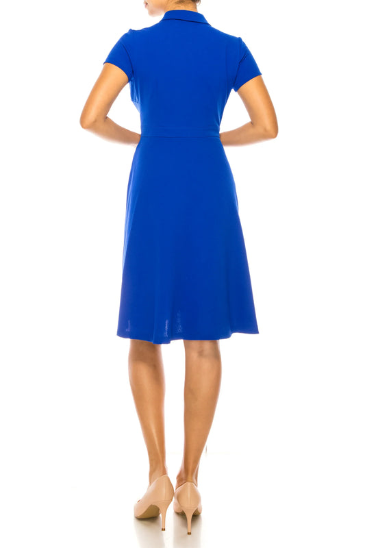 Back view of a woman wearing a royal blue short-sleeved midi dress and beige pumps.