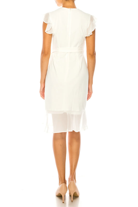Back view of a woman wearing an elegant white knee-length dress with ruffle sleeves and beige heels.