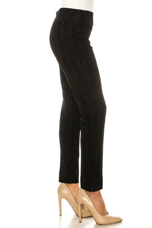 Woman wearing black textured slim-fit trousers and nude pointed-toe pumps.