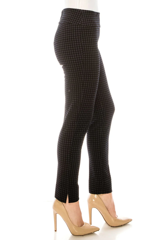 Woman wearing black and grey houndstooth patterned slim-fit trousers and nude heels.